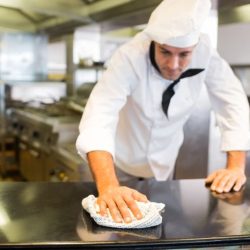 A food worker finishes cleaning and sanitizing the kitchen